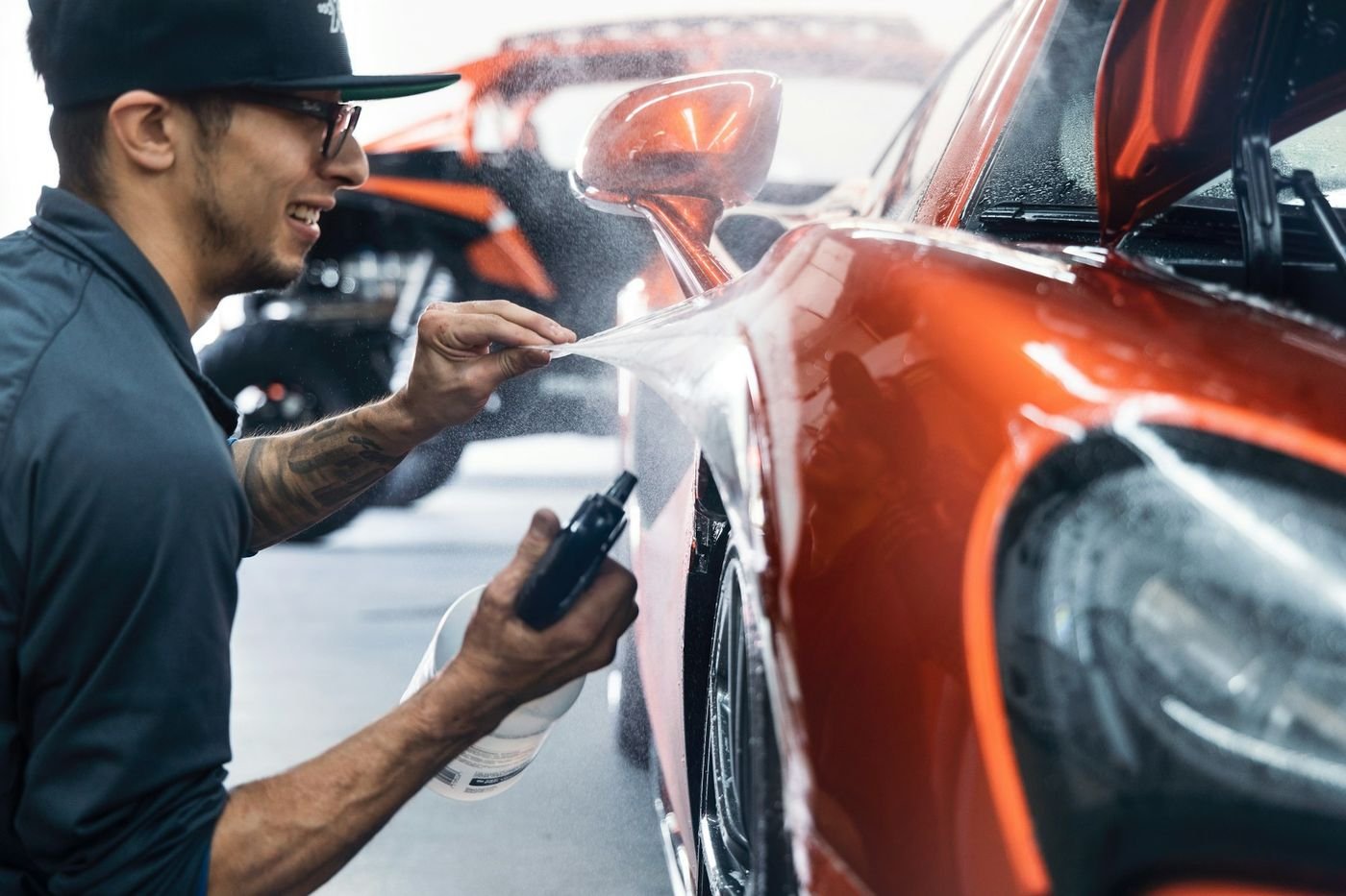 Film being squeegeed flat across a vehicle panel