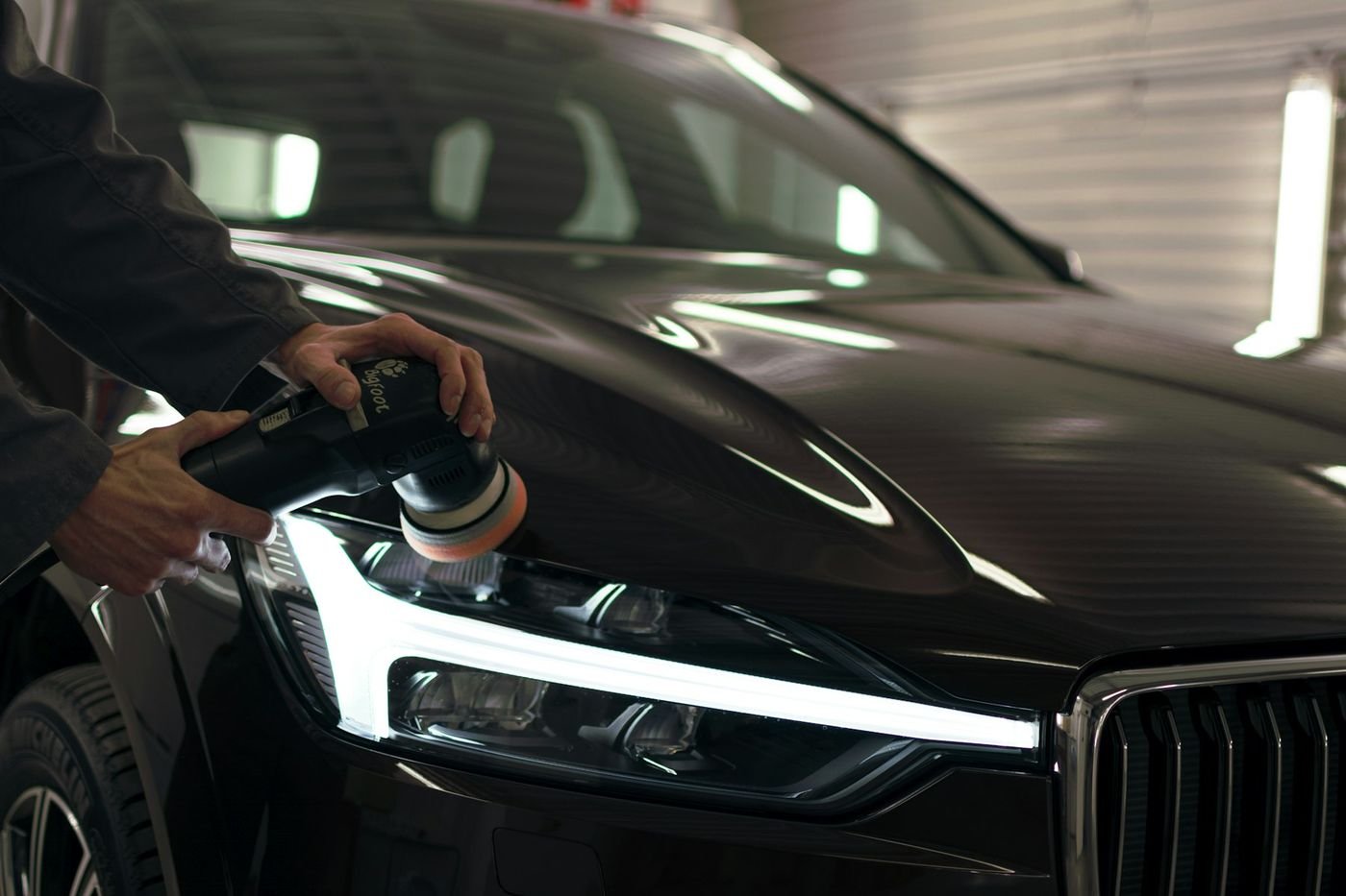 A Titan installer working a vehicle panel by hand in a controlled workshop